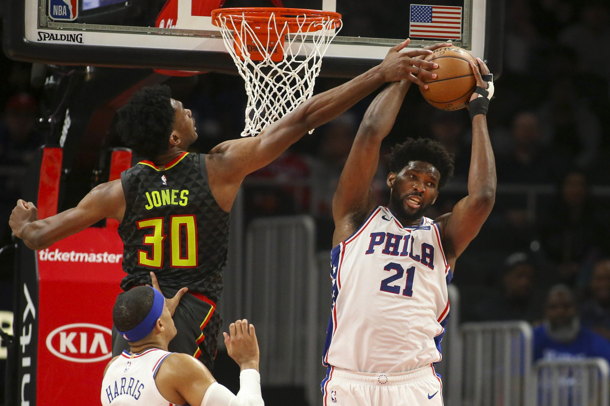Philadelphia 76ers center Joel Embiid grabs a rebound past Atlanta Hawks center Damian Jones